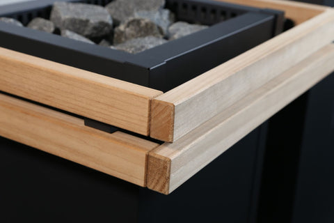 Harvia Virta sauna heater safety railing with natural wood frame and black metal brackets on white background