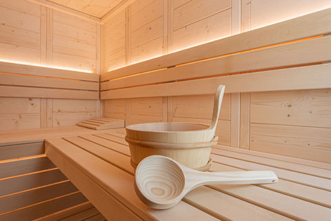 Wooden sauna pail with plastic insert and ladle, natural light wood finish on white background