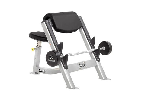 Hoist Preacher Curl weight machine with silver frame, black padded seat and backrest, and 60 pound Ivanko dumbbell, on white 