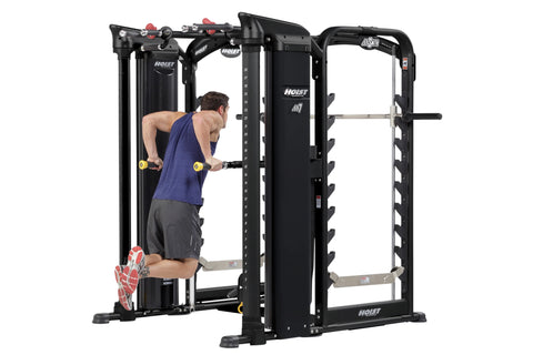 Hoist MI7 Smith functional trainer with black frame, cable stations with yellow pulleys, red adjustment knobs, and tan foot p