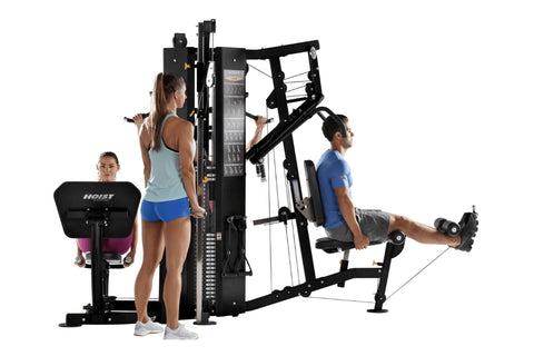 Hoist 4-Stack Multi Gym with black frame and red seat pad, three models demonstrating exercises on white background
