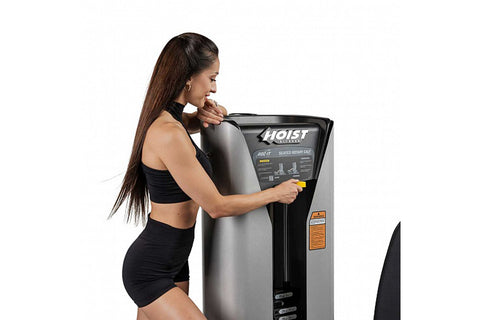 Hoist ROC-IT Rotary Calf Machine with gray and black frame, padded seat, and leg press platform on white background
