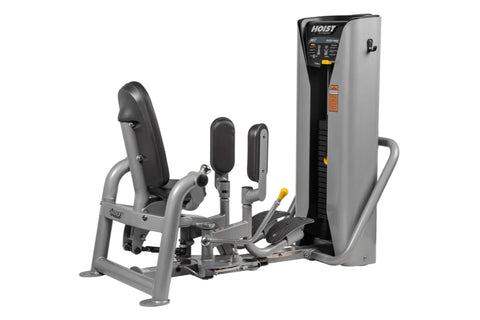 Hoist ROC-IT outer thigh machine with gray frame, black padded seat and leg press, control panel with orange accents on tall 
