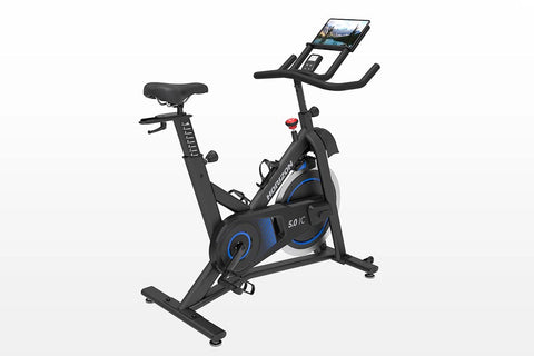 Black and blue indoor exercise bike with tablet holder and resistance dial, on white background
