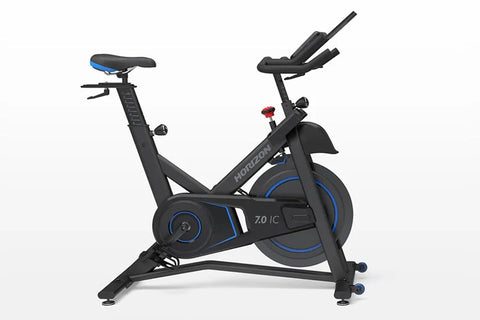 Horizon 7.0 IC black and blue indoor stationary bike with blue seat, digital display console, and dual handlebars on white ba