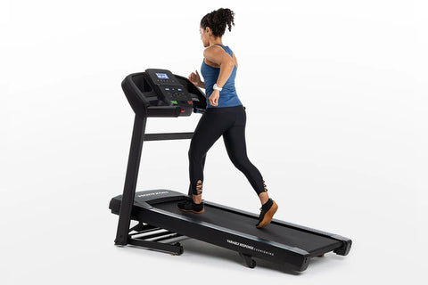 Black folding treadmill with blue accents, digital console display, control buttons, and handrails on white background
