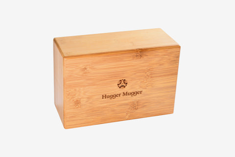 Natural bamboo yoga block with Hugger Mugger logo engraved on front, displayed on white background