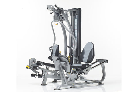 TuffStuff Hybrid Home Gym SXT-550 with gray frame, dual cable towers, leg press platform, and adjustable handles on white bac