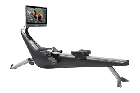 Hydrow Origin rowing machine with black seat and silver frame, featuring mounted tablet display showing workout video, on whi