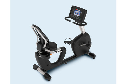 Black and silver recumbent exercise bike with digital display console and padded seat, on light blue background