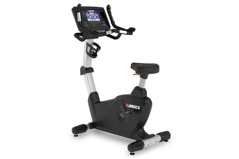 Landice U7 upright exercise bike with black frame, beige center post, digital console display, and foot pedals on light blue 