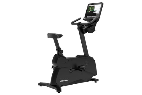 Black upright stationary exercise bike with digital console display, padded seat, handlebars, and stabilizing base on white b