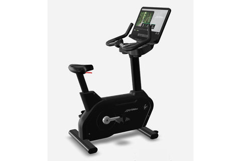 Black upright exercise bike with digital touchscreen display showing workout metrics, padded seat, handlebars, and foot pedal