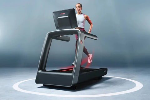 Black and gray Life Fitness treadmill with digital touchscreen display and blue accent lighting on running belt, viewed from 