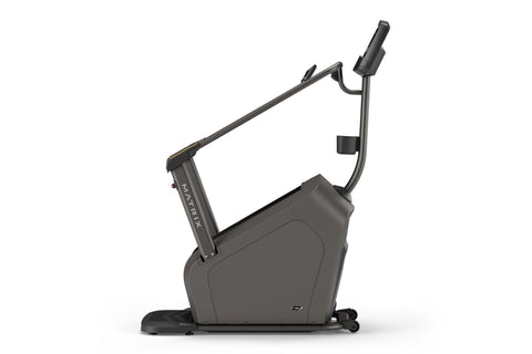 Black Matrix stair climber machine with digital display console, dual handrails with gold accents, and stepped platform on wh