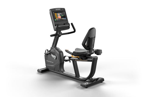 Matrix black recumbent exercise bike with digital touchscreen console displaying workout content, padded seat with backrest, 