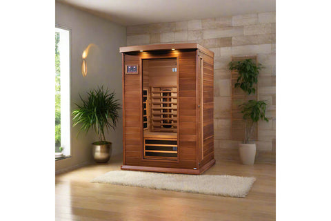 Red cedar two-person infrared sauna with glass front door, wooden benches, and overhead LED lighting on white background