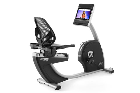 Black and silver recumbent exercise bike with mesh backrest, digital display monitor, and attached tablet holder on white bac