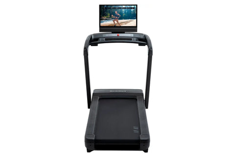 Black NordicTrack Commercial 2450 treadmill with integrated tablet display showing fitness video on white background