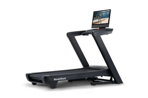 Black NordicTrack Commercial 2450 treadmill with integrated tablet display showing fitness video on white background