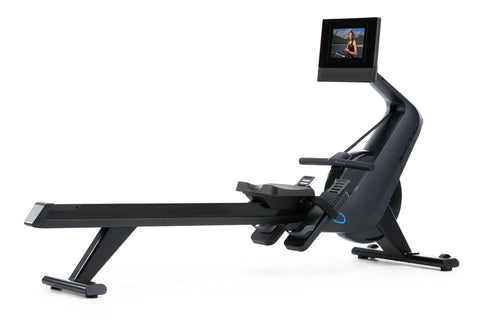 Black NordicTrack RW700 rowing machine with digital display monitor showing fitness video, featuring extended seat rail and f