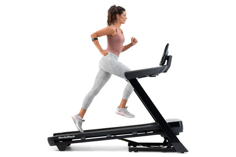 Black NordicTrack T-Series 10 treadmill with digital touchscreen console displaying workout content on white background