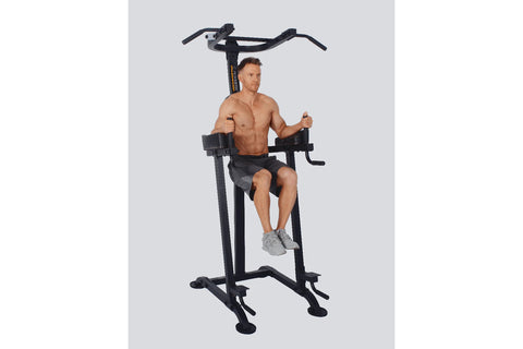 Black vertical power tower with dual handles, padded seat, leg extension platform, and stabilizing feet on white background