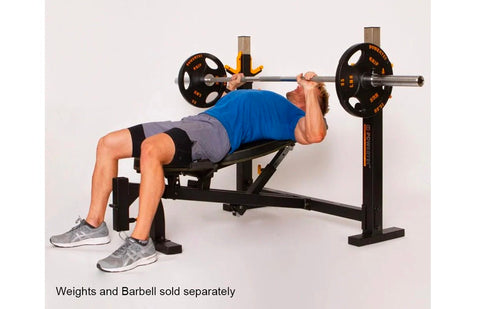 Black and yellow Olympic weight bench with dual squat racks and adjustable leg extension, on white background