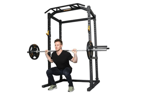 Black power rack with model performing barbell squat with weighted plates on white background
