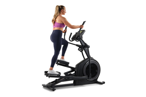 Black elliptical machine with dual handles, foot pedals, and digital display console on white background