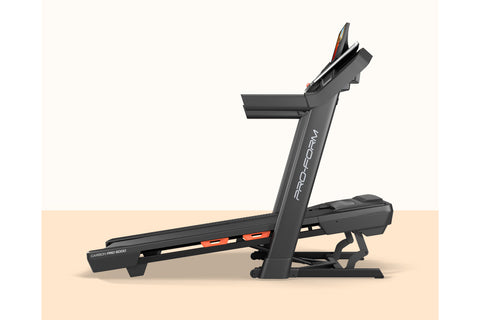 Black ProForm Carbon Pro 9000 treadmill with touchscreen display showing fitness video, padded running deck, and orange accen