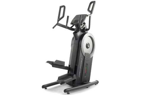 Man in white tank top and blue shorts using black ProForm elliptical machine with silver flywheel in home gym with brick wall