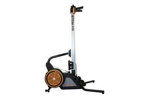 SKI-ROW AIR rowing machine with black frame, white vertical rail, orange and black flywheel, and extended footrest on white b