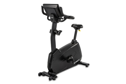 Spirit CU1000ENT black upright stationary exercise bike with digital display console and yellow handlebar accents, on white b