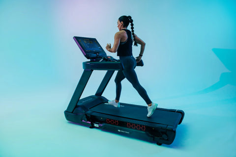 Black Star Trac treadmill with digital display console, cushioned running deck, and red accent lighting on white background