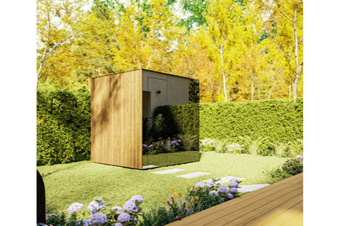 Modern outdoor sauna with natural wood and charcoal exterior in garden setting with hedges and flowering plants