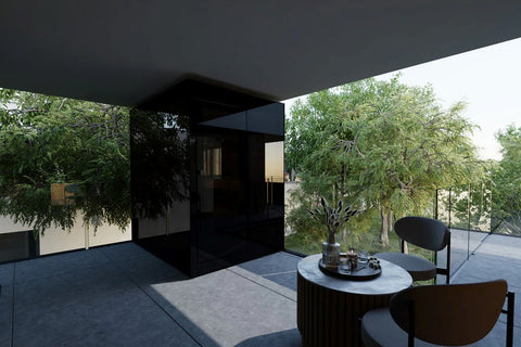 Black outdoor sauna with glass doors on modern patio, surrounded by green trees and contemporary furniture