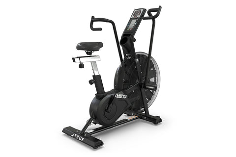 Black TRUE ADX exercise air bike with large fan wheel, digital display console, curved handlebars, black cushioned seat, and 