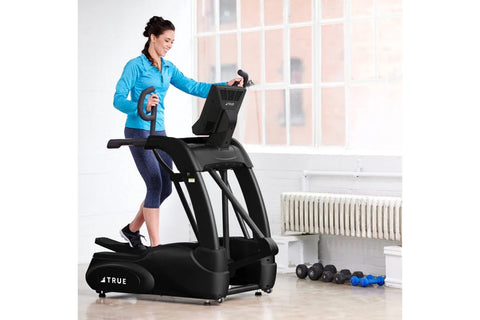Black TRUE elliptical machine with digital display console, curved foot pedals, and dual upper body handles on white backgrou