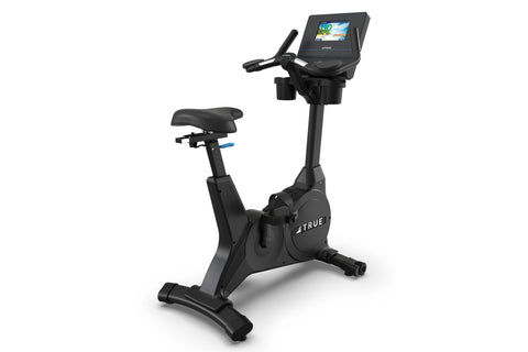 Black upright exercise bike with digital display console, padded seat, and handlebars on white background