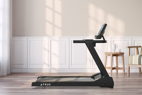 Black TRUE Z500 treadmill with digital blue display console, handrails, and wide running deck on white background