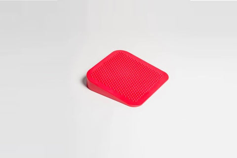 Pink textured balance wedge with model demonstrating use during abdominal exercise on white background