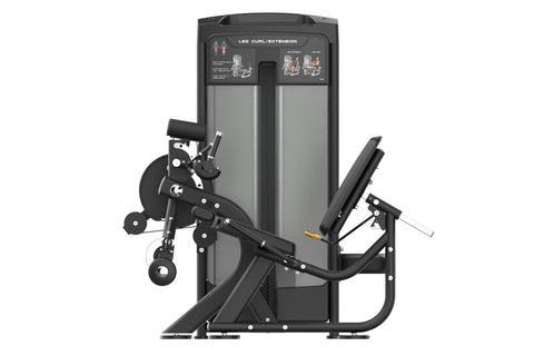 Black commercial leg curl and extension machine with padded seat, weight stack, and instruction panel on white background