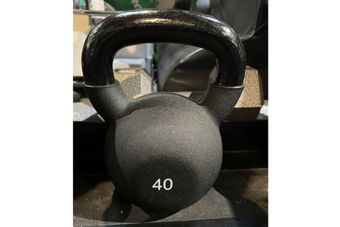 Two-tier black kettlebell rack holding nine neoprene-coated kettlebells labeled 15 to 50 pounds, on white background