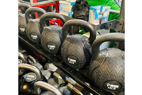 Two black rubber kettlebells with textured surfaces and looped handles, labeled 5LB and 10LB, displayed on white background