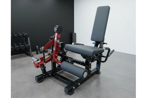 Red and black commercial leg extension and prone leg curl machine with padded seat, adjustable backrest, and weight plate peg