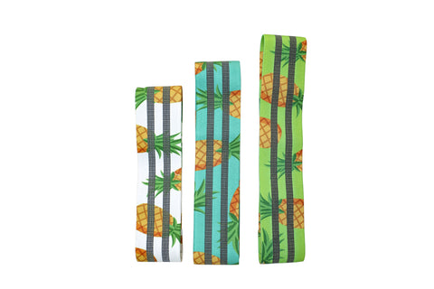 Three pineapple-print fabric stretch bands in white, turquoise, and lime green with golden pineapples and green leaves