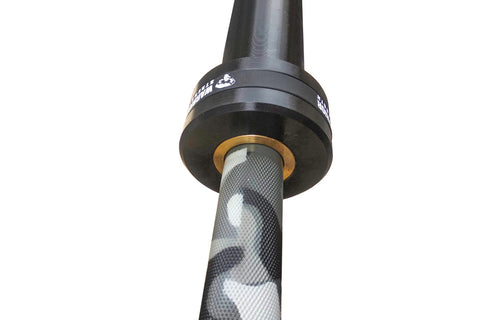 Warrior 6-bearing barbell with black cerakote sleeves and gray camouflage pattern shaft, gold collar rings