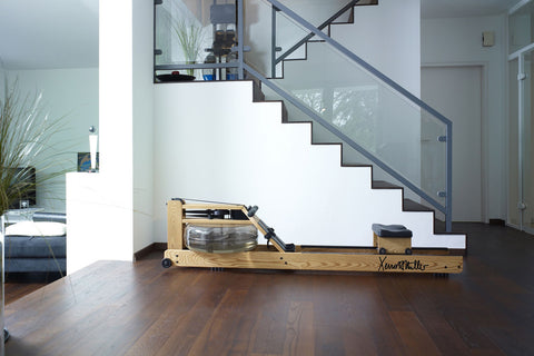 WaterRower Xeno Muller Signature Edition rowing machine with natural wood frame, black mechanical components, and water resis