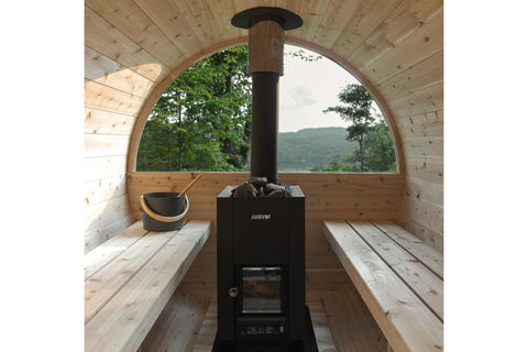 Harvia Linear 16 black wood-burning sauna stove heater with gray rocks in top chamber and visible flames in front door, on wh